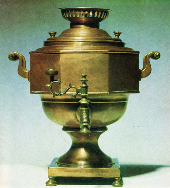 urn on a stand, with two handles on the dies and a spigot on front, with a burner on top