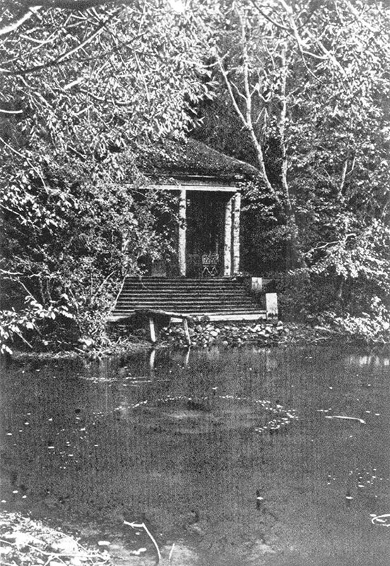 Pavilion by a lake, partially obscured by trees