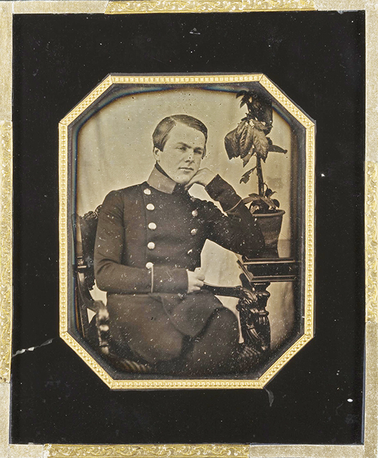 Daguerrotype of a young Vladimir Bobrinskii sitting at a desk with a plant on it, elbow on table, head resting in his hand