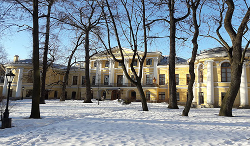 Colour image of the back face of the Bobrinskii Mansion, showing its position in the garden, white pillars and yellow walls